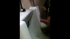 two slim dicks getting wanked at the urinals